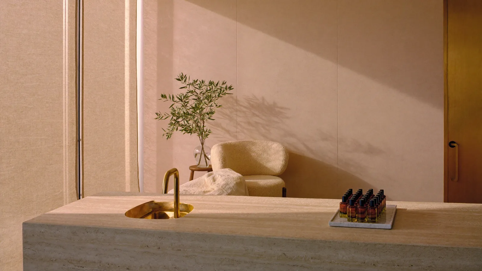 Warm travertine med spa reception with brass sink